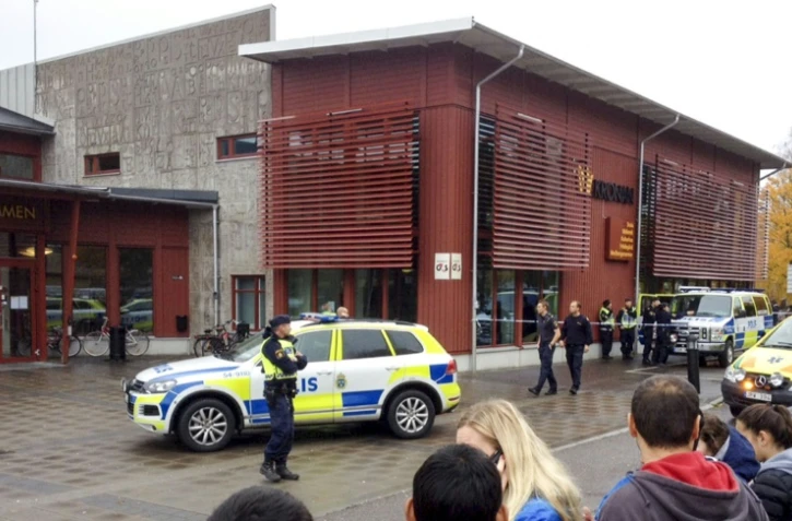 Des policiers devant une école où un homme masqué et armé d'un sabre a blessé cinq personnes, le 22 octobre 2015 à Trollhättan, en Suède