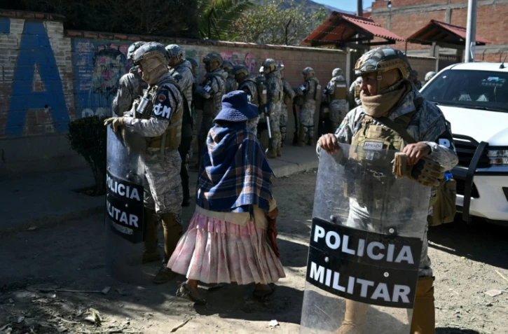 Des membres des forces de sécurité gardent une route après sa réouverture, auparavant bloquée par des manifestants exigeant la démission du président Rodrigo Paz,  le 5 juin 2026 à Carreras, dans le département de La Paz, en Bolivie