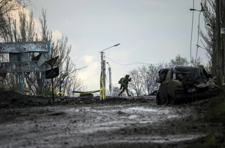 Un soldat ukrainien court pour se mettre à l'abri des bombardements sur la ligne de front à Bakhmout, dans l'est de l'Ukraine, le 23 avril 2023