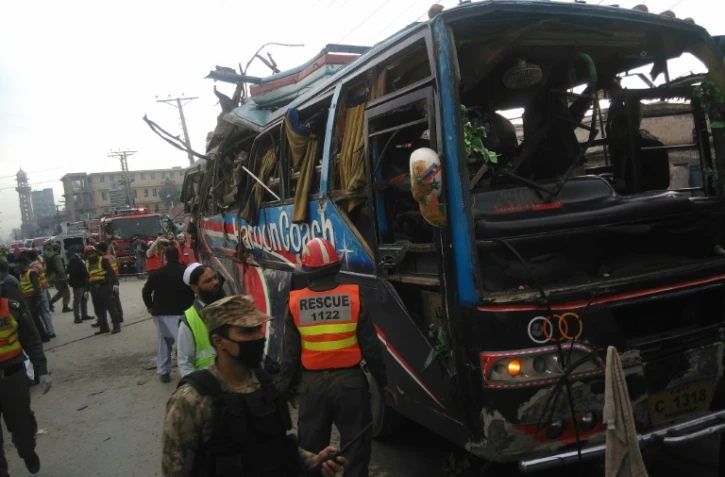 La police et les secours pakistanais sur le site de l'explosion d'un bus, à Peshawar au Pakistan, le 16 mars 2016