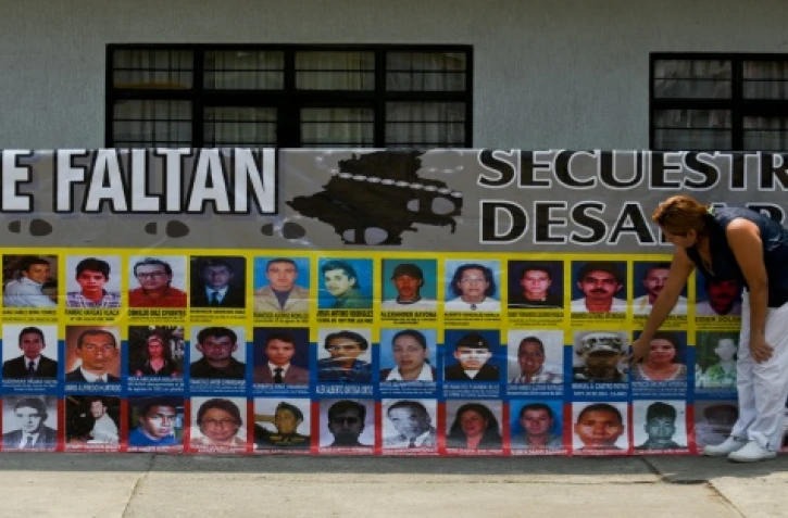 Mariela Patiño, mère de Manuel Castro Patiño, enlevé par les Farc en 2003, se tient devant une bannière présentant des photographies des disparus du conflit armé, à Cali en Colombie le 14 mars 2016