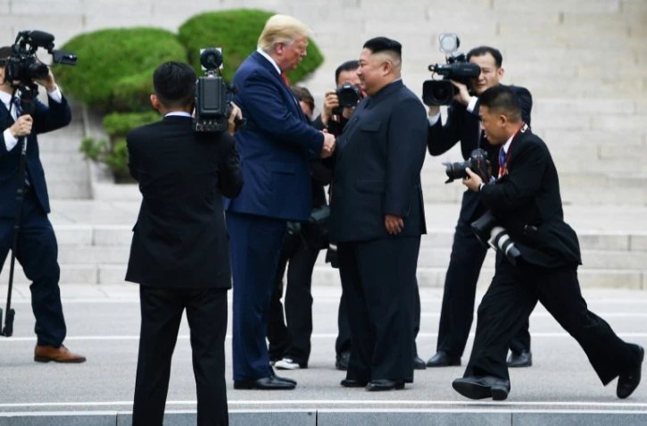 Le dirigeant nord-coréen Kim Jong Un et le président américain Donald Trump se serrent la main dans la zone démilitarisée, en Corée du Nord, à Panmunjom, le 30 juin 2019