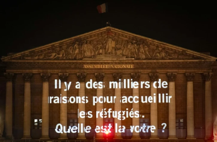 Un des messages projetés sur la façade de l'Assemblée nationale par Amnesty International France à Paris le 19 juin 2018 