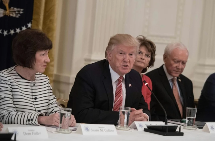 Le président américain Donald Trump entouré par les sénatrices républicaines Susan Collins (G) et Lisa Murkowski (D) le 27 juin 2017 à la Maison blanche à Washington