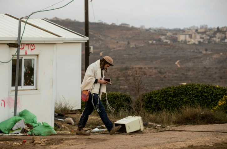 Un jeune habitant de la colonie sauvage d'Amona en Cisjordanie prie le 15 décembre 2016