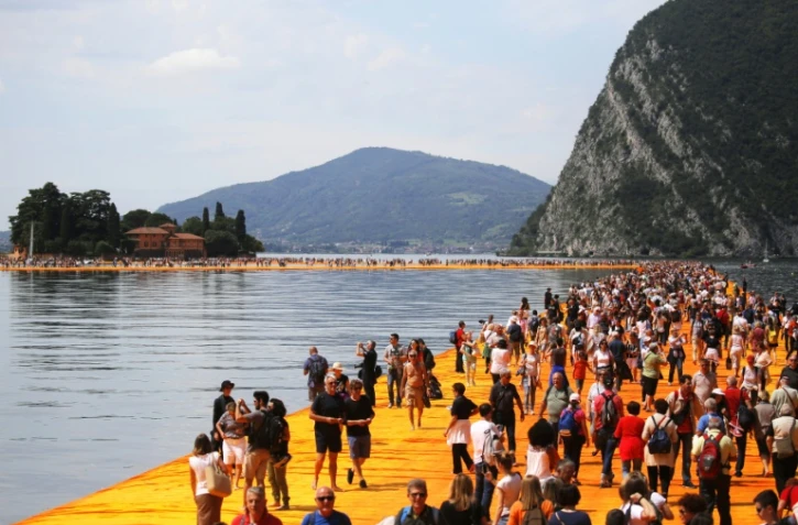 Des touristes déambulent sur les pontons flottants de Christo, sur le lac Iseo, en Italie, le 18 juin 2016