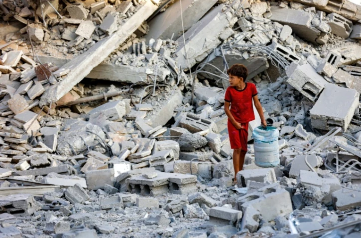 Un enfant fouille les décombres d'une tour d'habitation détruite par un bombardement israélien à Gaza-ville, le 9 septembre 2025