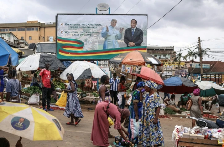 Les portraits du pape Léon XIV (g) et du président camerounais Paul Biya (d) sur une affiche géante à Yaoundé, à la veille de la visite du pape, le 13 avril 2026 au Cameroun