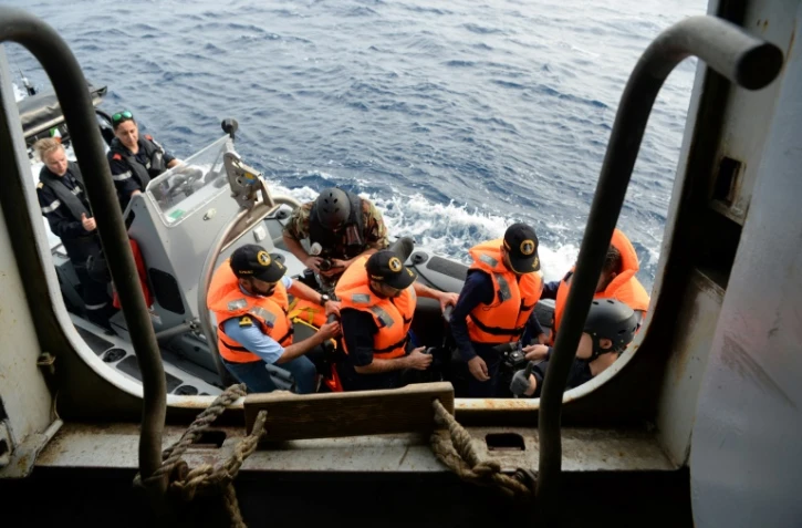 Des officiers médecins de la Marine iranienne se préparent à embarquer à bord du porte-hélicoptères français Mistral, le 28 mars 2022 au large de Goa, dans l'océen Indien