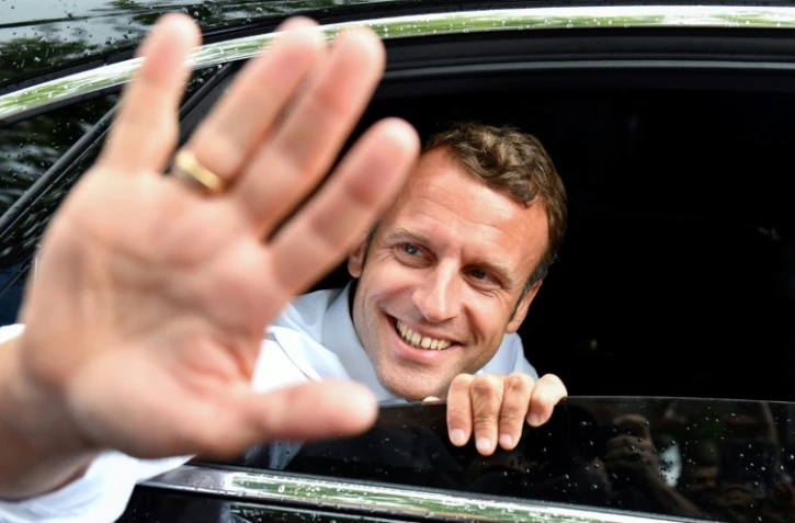 Emmanuel Macron salue la foule le 27 juillet 2019 lors d'un passage à Bormes-les-Mimosas (sud)