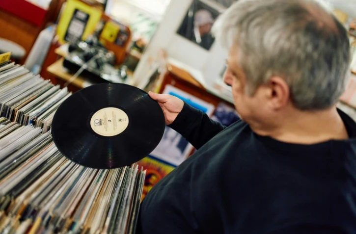 Un client examine un vinyle de la boutique Flashback Records, le 18 avril 2024 Ă Londres