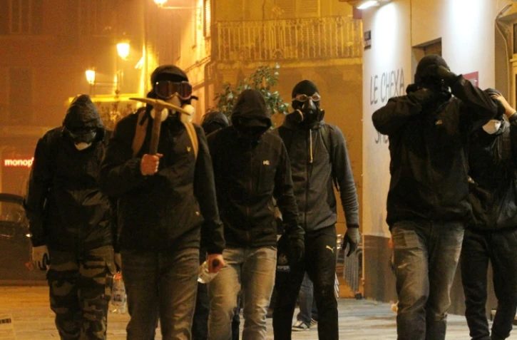 Un groupe d'hommes cagoulés marche le 14 février à Bastia lors d'un rassemblement en soutien à un supporteur du Sporting Club de Bastia blessé à Reims