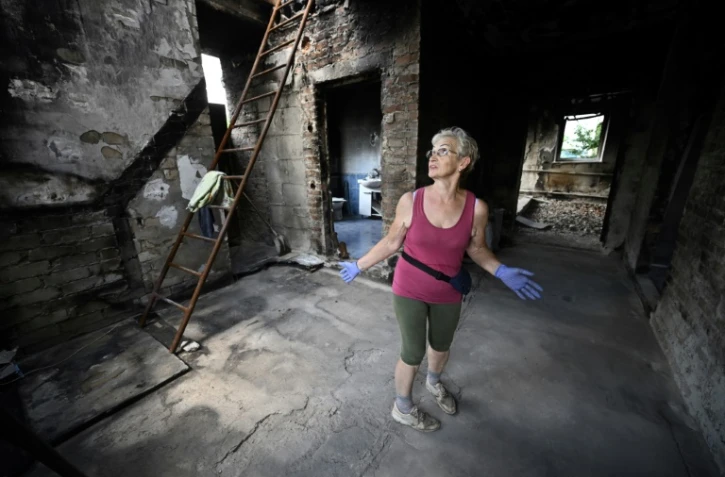 Galyna Kios montre l'étendue des dégâts à son domicile dans le village  ukrainien de Mala Rogan, proche de la frontière russe et théâtre de combats acharnés, le 28 juillet 2022