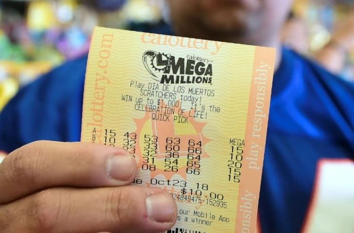 Un homme montre son ticket avant le tirage du super jackpot de 1,6 milliard, acheté dans une épicerie de Hawthorne, en Californie, le 23 octobre 2018