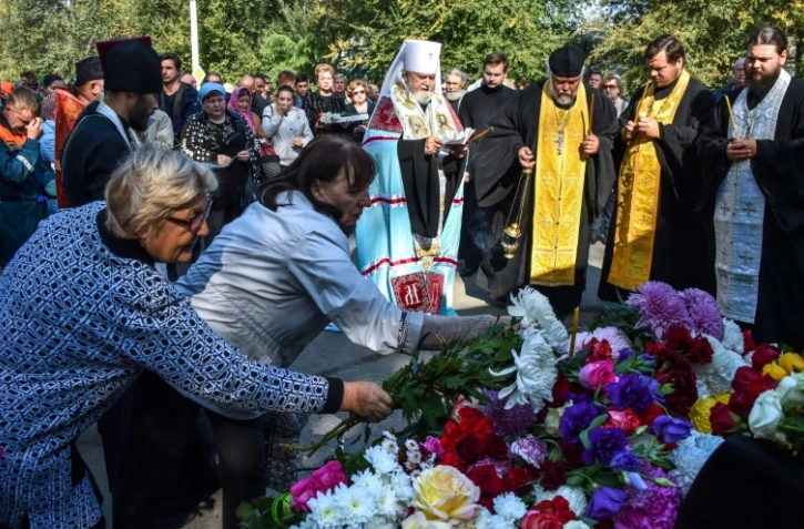 Des gens déposent des fleurs à Kertch lors d'une cérémonie d'hommages à la tuerie du lycée polytechnique, le 18 octobre 2018