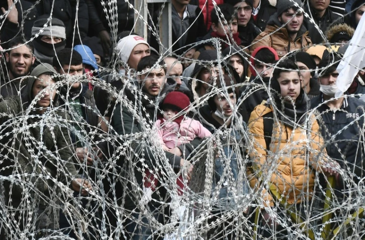 Des migrants derrière des barbelés à la frontière entre la Turquie et la Grèce près de des Kastanies, en Grèce, le 2 mars 2020
