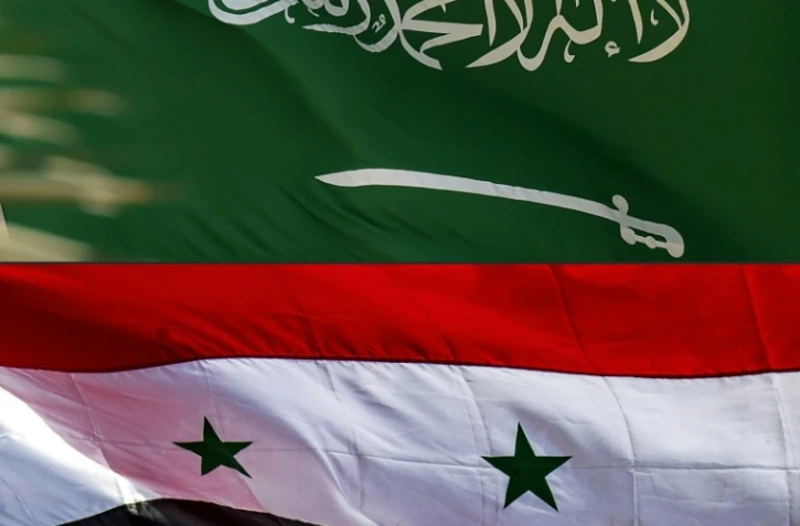 Cette combinaison d'images créée le 23 mars 2023 montre un drapeau national saoudien à Riyad le 22 septembre 2020 (en haut) et un drapeau national syrien à Qamishli, le 5 novembre 2019