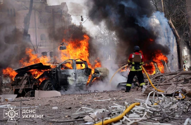 Un pompier tente d'éteindre l'incendie d'une voiture, après une attaque russe à Soumy, dans le nord-est de l'Ukraine, le 13 avril 2025