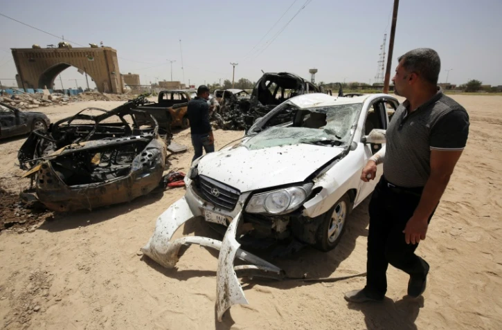 Des véhicules détruits lors d'un attentat suicide le 13 juillet 2016 à Bagdad