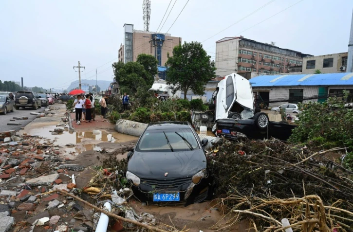 La population constate les dégâts après les intempéries à Mihe, dans la province de Henan (centre de la Chine), le 22 juillet 2021