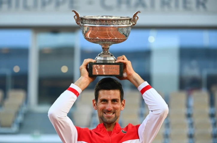 Le Serbe Novak Djokovic brandit son trophée après sa victoire en finale contre le Grec Stefanos Tsitsipas, à Roland-Garros, le 13 juin 2021
