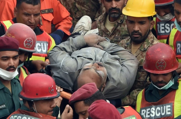 Un homme extrait des décombres par les sauveteurs le 5 novembre 2015 après l'effondrement d'une usine à Lahore