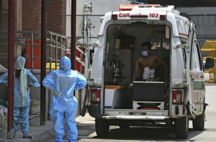 Un homme attend dans une ambulance devant l'entrée de l'unité réservée aux patients atteints du coronavirus de l'hôpital Lok Nayak Jai Prakash, le 11 juin 2020 à New Delhi, en Inde