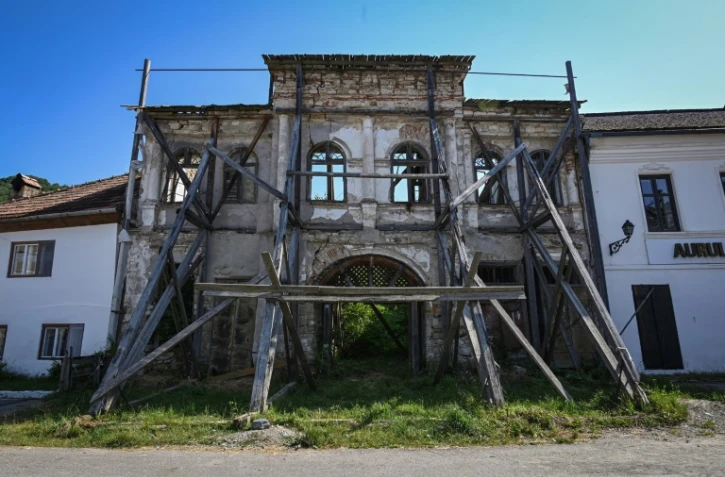 La façade d'une maison ancienne, dont l'intérieur s'est effondré, soutenue par des piliers en bois, le 13 juillet 2021
à Rosia Montana, dans l'ouest de la Roumanie