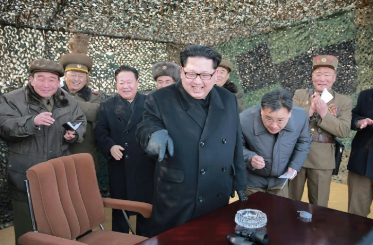 Photo non datée publiée le 4 mars 2016 par l'agence officielle nord-coréenne KCNA montrant le dirigeant nord-coréen Kim Jong-Un (c) lors d'une inspection militaire