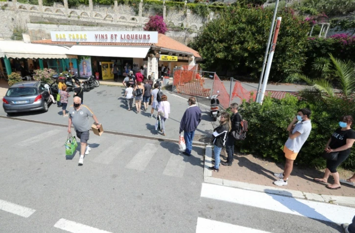 Des gens font la queue pour acheter des cigarettes du côté italien à la frontière franco-italienne près de Menton le 3 juin 2020 alors que l'Italie rouvre ses frontières avec l'Europe