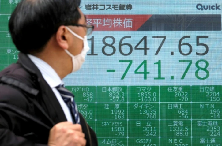 Un tableau électronique affiche le recul des cours à la Bourse de Tokyo, le 30 mars 2020