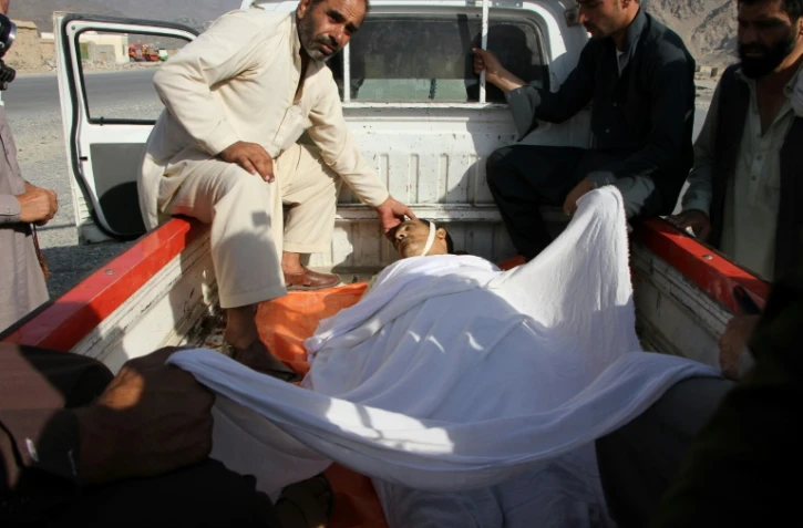 Des hommes transportent un autre homme tué dans un attentat dans l'est de l'Afghanistan, le 11 septembre 2018