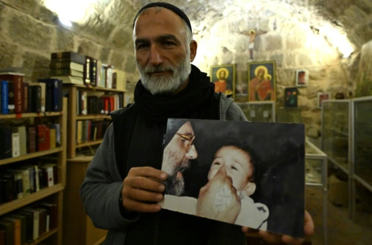 Le père Jihad Youssef tient un portrait du père Pablo au monastère Deir Mar Moussa al-Habachi à Nabek dans le nord de la Syrie, le 8 février 2025