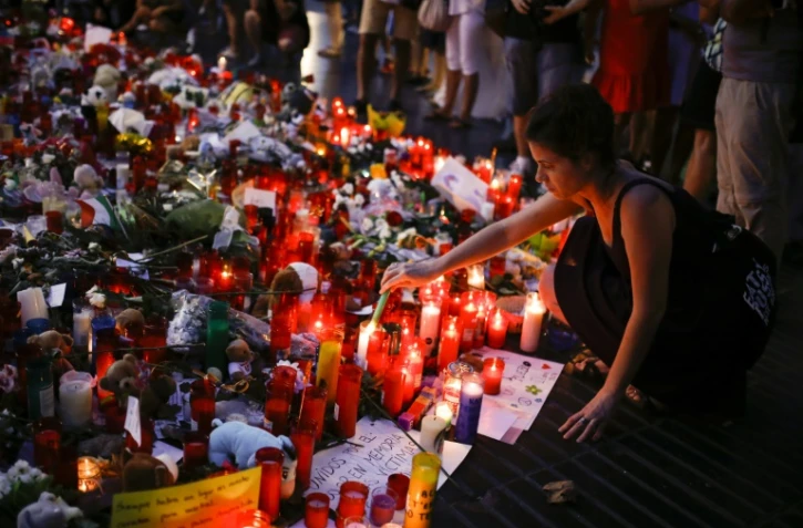 Des gens déposent des fleurs, messages et bougies en hommage aux victimes des attentats de Barcelone et Cambrils sur les Ramblas le 22 août 2017