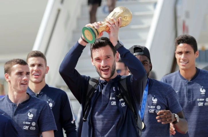 Le capitaine et gardien de l'équipe de France Hugo Lloris brandit la Coupe du monde, à l'arrivée à Roissy le 16 juillet 2018