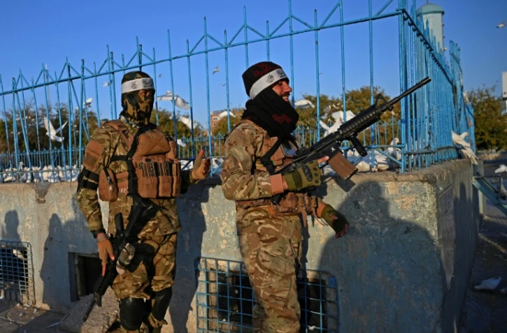 Deux combattants talibans montent la garde devant une mosquée de Mazar-i-Sharif, le 30 octobre 2021 