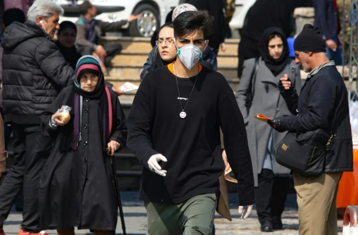 Des piétons, certains portant un masque de protection, dans une rue de Téhéran, le 22 février 2020 en Iran