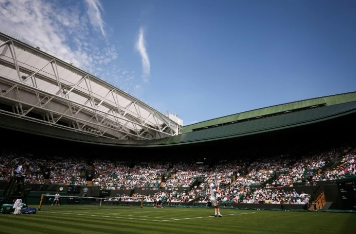 L'Italien Jannik Sinner (à droite) au service le 1er juillet 2025 à Wimbledon près de Londres 