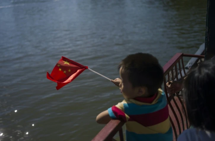Un enfant tient un drapeau de la République populaire de Chine, en septembre 2015