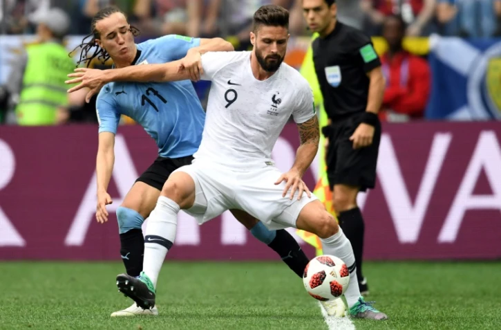 L'avant-centre de l'équipe de France Olivier Giroud prend le meilleur sur l'Uruguayen Diego Laxalt à Nijni Novgorod, le 6 juillet 2018