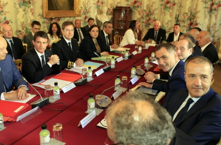 Le Premier ministre Manuel Valls (G) entouré à G du ministre des Collectivités Jean-Michel Baylet et à D du préfet de Corse Bernard Schmeltz devant le président de l'Assemblée de Corse Jean-Guy Talamoni (D) à Ajaccio le 4 juillet 2016