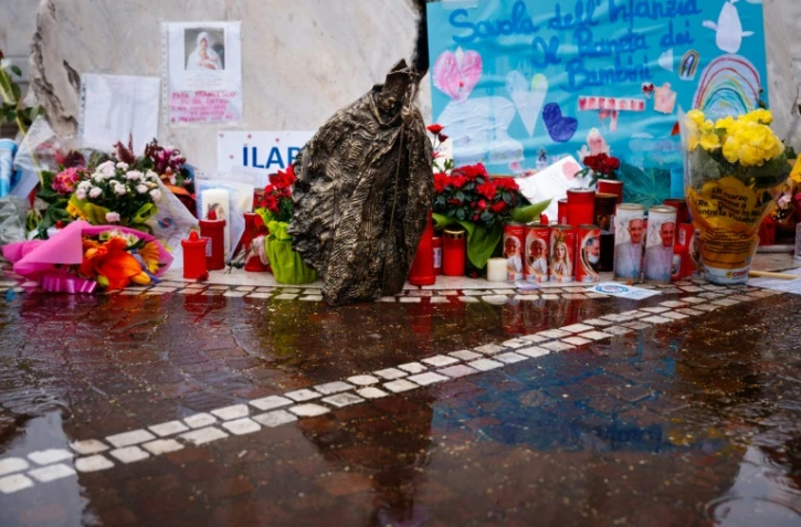 Des fleurs, bougies, messages et une sculpture déposés au pied de la statue de Jean Paul II devant l'hôpital Gemelli à Rome, où est hospitalisé le pape François, le 1er mars 2025