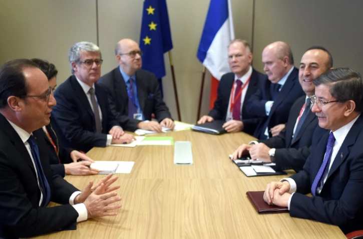 Le president français François Hollande (g) rencontre le Premier ministre turc Ahmet Davutoglu (d) et le ministre des Affaires étrangères Mevlut Cavusoglu (2e à d), à Bruxelles le 18 mars 2016