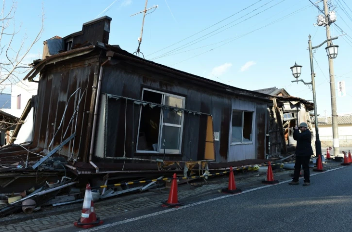 Un "touriste" photographie une des maisons abandonnées de Namie, dans la région de Fukushima, le 11 février 2016, 5 ans après l'accident nucléaire