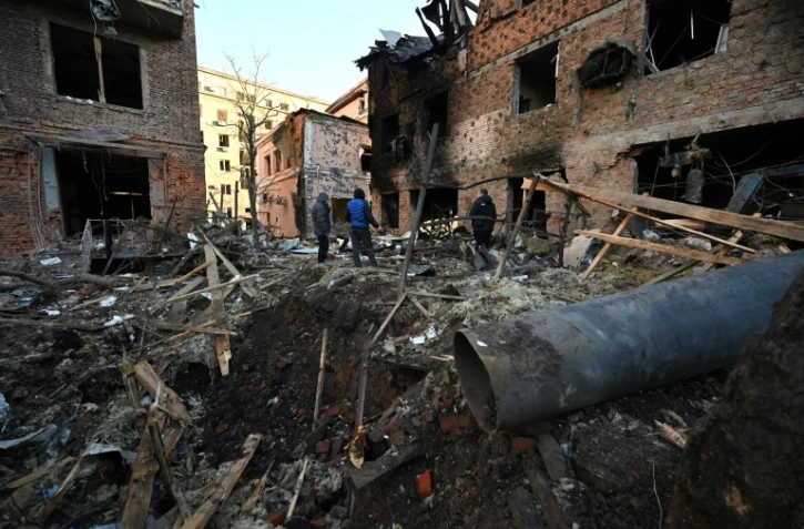 Des habitants inspectent les décombres de bâtiments le 31 décembre 2023 à Kharkiv, dans l'est de l'Ukraine, après des attaques de drones