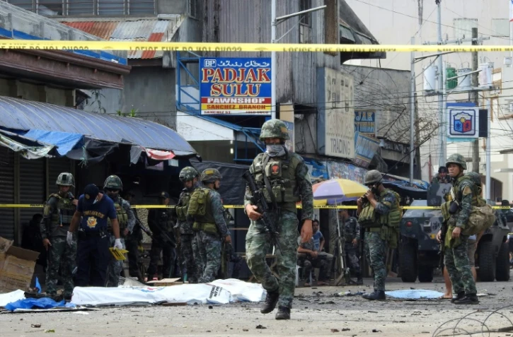 Des policiers et soldats sur les lieux d'un double attentat contre la cathédrale de Jolo, le 27 janvier 2019 aux Philippines