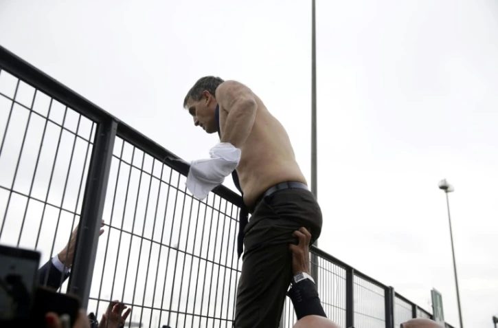 Xavier Broseta, ex-DRH d'Air France, tente de franchir un grillage après avoir été pris à partie par des salariés de la compagnie aérienne à Roissy, le 5 octobre 2015