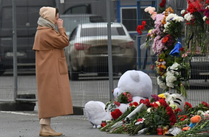 Une femme se recueille devant un mémorial improvisé près du Crocus City Hall de Krasnogorsk, dans la banlieue de Moscou, théâtre d'une attaque meurtrière, le 23 mars 2024