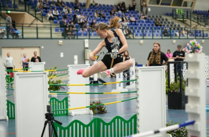 Une participante concourt dans la catégorie saut d'obstacles des Championnats finlandais de cheval bâton dans l'arène sportive de Seinäjoki, le 15 juin 2024
