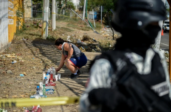 Une femme allume une bougie sur le lieu d'un accident qui a coûté la vie à 55 migrants près de Tuxtla Gutierrez (Mexique), le 10 décembre 2021